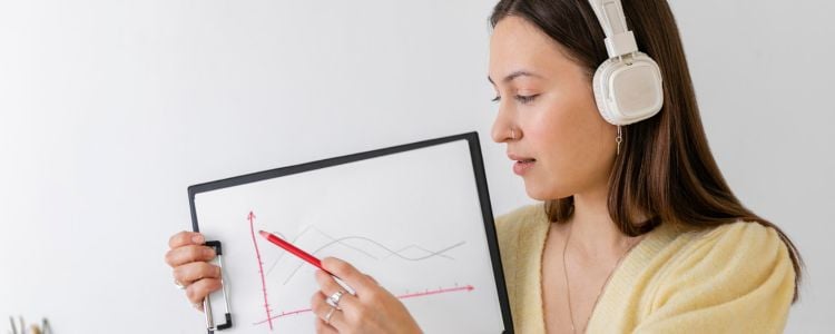Mujer con audífonos mostrando un gráfico tras estudiar su maestría ideal