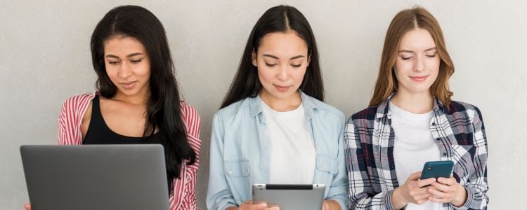 Mujeres trabajando con laptop y celulares en el Día del Estudiante